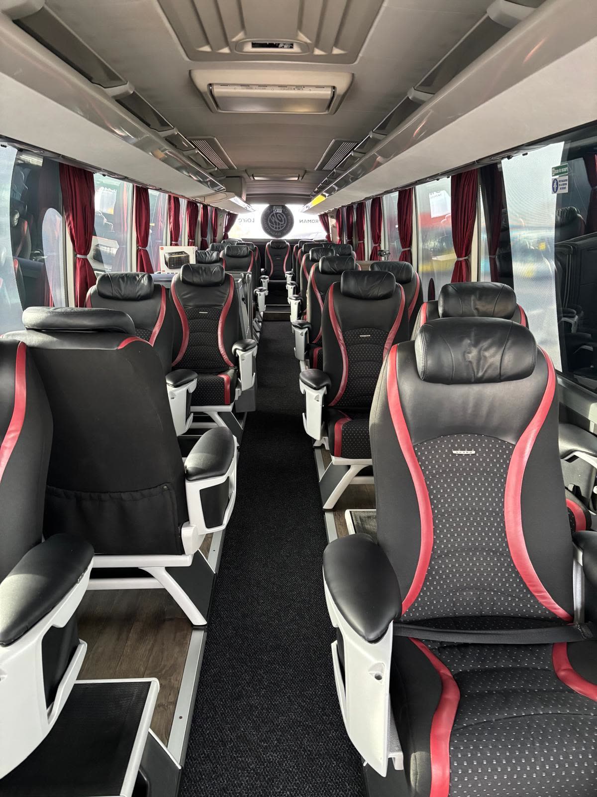 Allée centrale d'un autocar VertiGo avec sièges grand confort noir et rouge